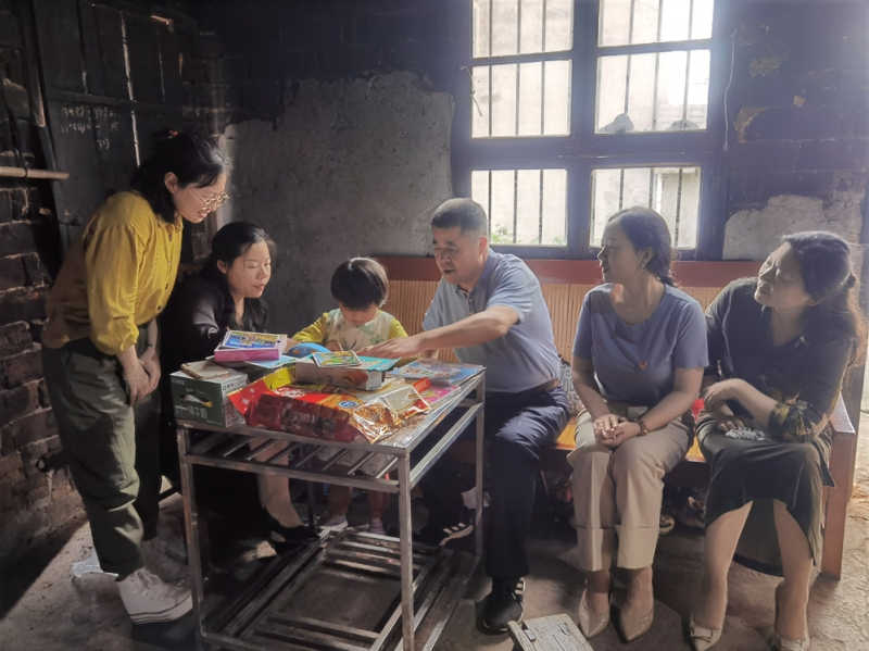 市财政局一级调研员彭志强和爱心妈妈们一起陪同小丽萍阅读绘本、做手工