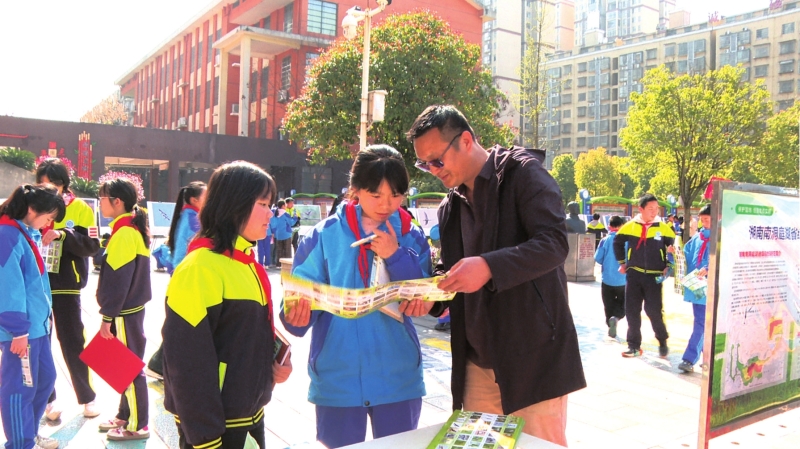 志愿者在南洞庭实验学校宣传鸟类知识。