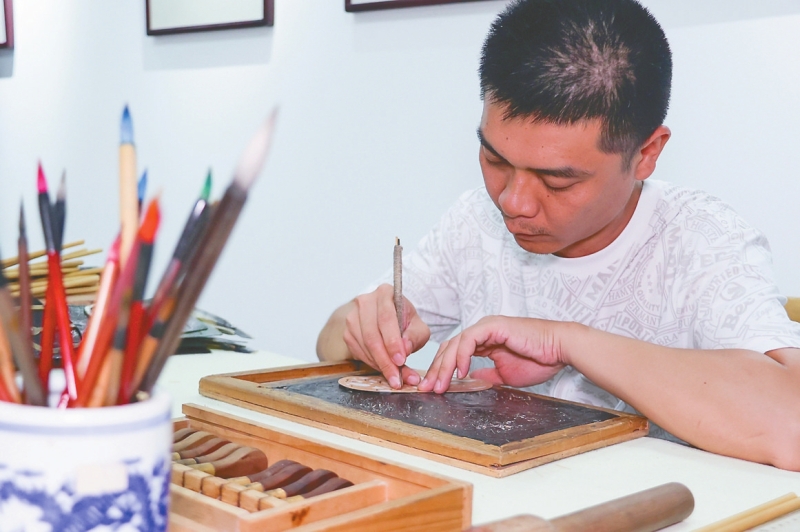 湖南省非遗项目益阳纸影制作技艺代表性传承人朱龙在雕刻作品。